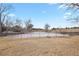Community pond with bare trees and a wrought iron fence at 17034 E Tennessee Dr # 106, Aurora, CO 80017