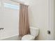 Bright bathroom featuring tub-shower combo, tile surround, shower curtain, and toilet at 2682 E 161St Pl, Thornton, CO 80602
