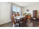Dining area with dark wood floors, modern table set, and bright natural light at 2682 E 161St Pl, Thornton, CO 80602