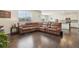 Spacious living room boasts a large leather sectional, hardwood floors and abundant natural light at 2682 E 161St Pl, Thornton, CO 80602