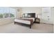 Serene bedroom with large windows, neutral carpet, and a comfortable bed with side tables and lamps at 2682 E 161St Pl, Thornton, CO 80602