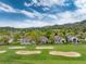 Breathtaking aerial view of the golf course community, showcasing meticulously maintained greens and surrounding mountain landscape at 15851 Deer Ridge Dr, Morrison, CO 80465