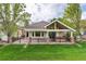 Expansive backyard with a covered patio, a hot tub, a well-maintained lawn, and mature trees at 15851 Deer Ridge Dr, Morrison, CO 80465
