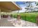 Covered patio with a hot tub, string lights, and views of the lush golf course and distant mountains at 15851 Deer Ridge Dr, Morrison, CO 80465