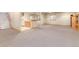 Spacious carpeted basement featuring a staircase, wet bar, and natural light at 15851 Deer Ridge Dr, Morrison, CO 80465