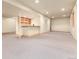 Expansive carpeted basement with a bar area, built-in shelving, and neutral paint at 15851 Deer Ridge Dr, Morrison, CO 80465
