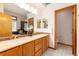 Main bath boasting dual sinks, framed mirrors, and separate toilet area at 15851 Deer Ridge Dr, Morrison, CO 80465