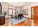 Dining room featuring wooden floors, large windows with wood shutters, and a tray ceiling with a chandelier at 15851 Deer Ridge Dr, Morrison, CO 80465