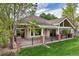 Back of home featuring a covered patio with a hot tub, and a landscaped yard at 15851 Deer Ridge Dr, Morrison, CO 80465