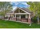 Back of the home featuring a covered patio with a hot tub and a grassy yard at 15851 Deer Ridge Dr, Morrison, CO 80465