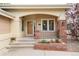 Inviting front porch with brick accents, a covered entrance, and manicured landscaping at 15851 Deer Ridge Dr, Morrison, CO 80465