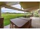 Covered back patio featuring a hot tub with views of the golf course at 15851 Deer Ridge Dr, Morrison, CO 80465