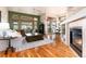 Cozy living room featuring a fireplace, wood floors, and a view to the breakfast nook and backyard at 15851 Deer Ridge Dr, Morrison, CO 80465