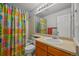 Functional bathroom with a single vanity, tub-shower, and vibrant, patterned shower curtain at 1120 N Calhan Ave, Castle Rock, CO 80104