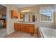 Bright bathroom featuring a dual sink vanity, soaking tub, and a walk-in closet at 1120 N Calhan Ave, Castle Rock, CO 80104