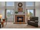Cozy brick fireplace featuring white mantle, a painting and windows on either side at 1120 N Calhan Ave, Castle Rock, CO 80104