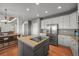 Open kitchen features stainless steel appliances, a kitchen island with a cooktop, and hardwood flooring at 1120 N Calhan Ave, Castle Rock, CO 80104