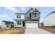 Two-story home boasts a two-car garage, and a blend of white and green siding at 39730 Congress Ln, Elizabeth, CO 80107