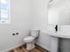Half bathroom features a pedestal sink, a toilet, and a large mirror at 39730 Congress Ln, Elizabeth, CO 80107