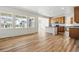 Open concept living room with lots of natural light, kitchen view, and wood flooring at 39730 Congress Ln, Elizabeth, CO 80107