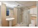 Bright bathroom featuring glass enclosed walk-in shower, pedestal sink and toilet at 7169 S Grape Ln, Centennial, CO 80122