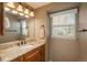 Bathroom showcasing granite counters, wood cabinets, and a window providing natural light and ventilation at 7169 S Grape Ln, Centennial, CO 80122