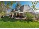 Exterior view of home with backyard featuring covered patio, lush lawn, and mature trees at 7169 S Grape Ln, Centennial, CO 80122