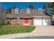 Charming two-story brick home with dormer windows, red door, manicured lawn, and attached two car garage at 7169 S Grape Ln, Centennial, CO 80122