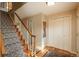 Traditional hallway with carpeted stairs, wood trim, and a coat closet providing ample storage at 7169 S Grape Ln, Centennial, CO 80122