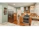 Beautiful kitchen with stainless steel appliances, granite countertops, custom cabinets, and hardwood flooring at 7169 S Grape Ln, Centennial, CO 80122