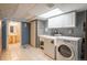 Well-lit laundry room with washer, dryer, utility sink, storage cabinets and access to a bathroom at 7169 S Grape Ln, Centennial, CO 80122