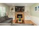 Cozy living room features built-in cabinets, a stone fireplace with flatscreen TV, and a plush gray sectional at 7169 S Grape Ln, Centennial, CO 80122