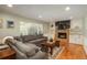 Inviting living room with a stone fireplace, built-in shelving, and large window providing plenty of natural light at 7169 S Grape Ln, Centennial, CO 80122