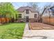 Charming backyard with manicured lawn, garden beds, and brick accents, perfect for outdoor enjoyment at 2235 S Fillmore St, Denver, CO 80210