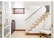 Basement staircase featuring carpeted steps and handrail, alongside a window and decorative accents at 2235 S Fillmore St, Denver, CO 80210