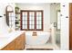 Bathroom featuring a soaking tub, glass-enclosed shower, vanity, and natural light at 2235 S Fillmore St, Denver, CO 80210