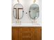 Bathroom vanity featuring double sinks, white countertop, wood cabinet and oval mirrors at 2235 S Fillmore St, Denver, CO 80210
