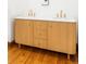 Bathroom featuring a double sink vanity with marble countertop, wood trim, and gold hardware at 2235 S Fillmore St, Denver, CO 80210