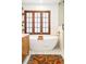 Bright bathroom featuring a standalone tub with wood trim window and gold fixtures at 2235 S Fillmore St, Denver, CO 80210