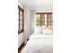 Comfortable bedroom featuring natural light, neutral decor, and wood-framed windows at 2235 S Fillmore St, Denver, CO 80210