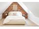 Bedroom with a brick accent wall with unique macrame and neutral color pallet at 2235 S Fillmore St, Denver, CO 80210