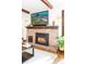 Living room featuring a cozy fireplace with brick surround, and wooden beams on the ceiling at 2235 S Fillmore St, Denver, CO 80210