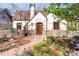 Charming Tudor-style home featuring brick accents, arched doorway, and professionally landscaped front yard at 2235 S Fillmore St, Denver, CO 80210