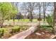 Inviting front yard with a brick pathway, lush landscaping, and a classic white picket fence at 2235 S Fillmore St, Denver, CO 80210