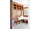 Mudroom with custom wood built-ins, bench, and black and white geometric patterned floor tile at 2235 S Fillmore St, Denver, CO 80210