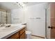 Bright bathroom featuring a single sink vanity, large mirror, and a walk-in shower at 2883 W Long Cir # E, Littleton, CO 80120