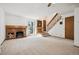 Spacious living room with a brick fireplace, a staircase, and neutral carpet at 2883 W Long Cir # E, Littleton, CO 80120