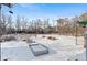 Snowy backyard with garden beds and wooden barrels at 1435 Quebec St, Denver, CO 80220