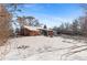 Spacious backyard with snow covered ground and mature trees at 1435 Quebec St, Denver, CO 80220