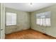 Simple bedroom with hardwood floors and two windows at 1435 Quebec St, Denver, CO 80220